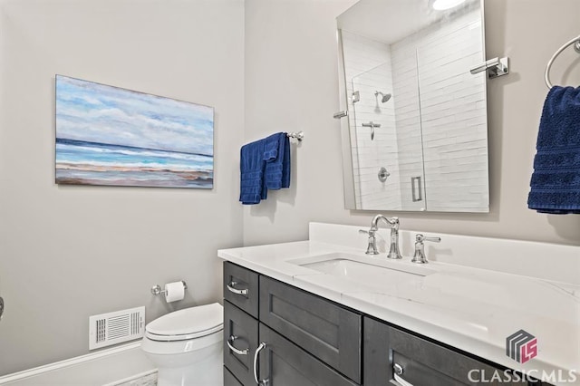 bathroom with vanity, an enclosed shower, and toilet