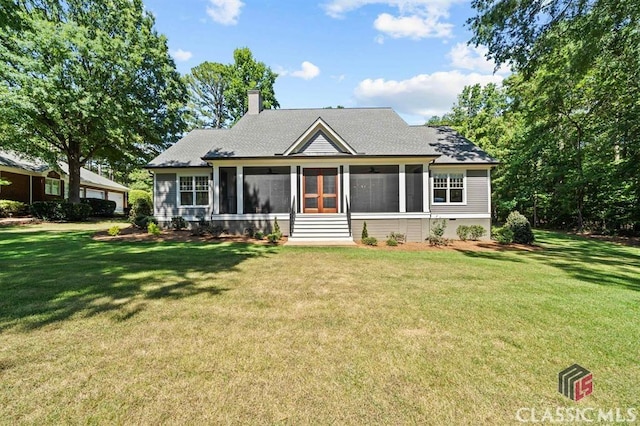 view of front of property featuring a front yard and a sunroom