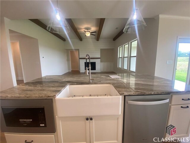216 Montview Dr, Jefferson, GA 30549 - kitchen featuring appliances with stainless steel finishes, a sink, open floor plan, white cabinets, and beam ceiling