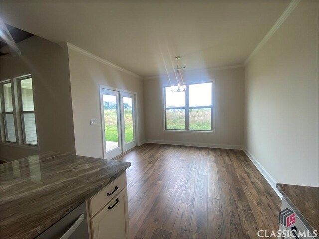 216 Montview Dr, Jefferson, GA 30549 - unfurnished dining area featuring dark wood finished floors, healthy amount of natural light, a chandelier, baseboards, and crown molding