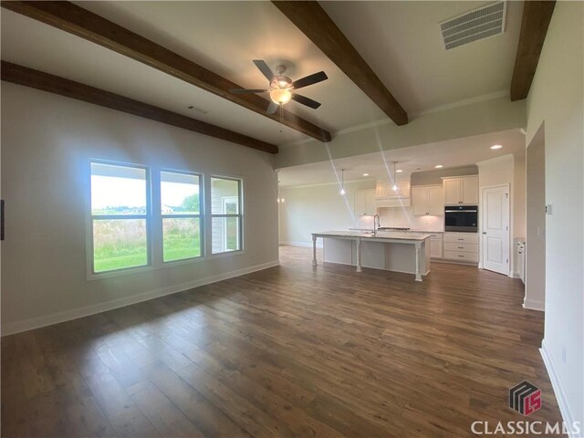 216 Montview Dr, Jefferson, GA 30549 - unfurnished living room featuring beamed ceiling, baseboards, a ceiling fan, dark wood-style flooring, and a sink