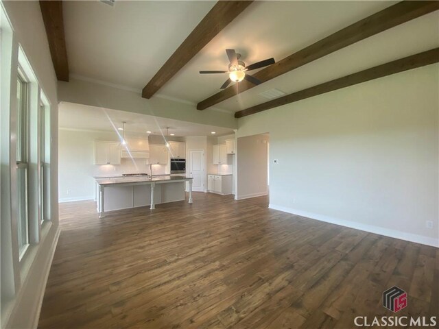 216 Montview Dr, Jefferson, GA 30549 - unfurnished living room featuring beamed ceiling, dark wood-style flooring, ceiling fan, baseboards, and recessed lighting