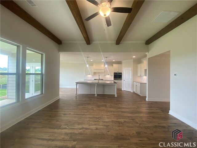 216 Montview Dr, Jefferson, GA 30549 - kitchen featuring oven, beam ceiling, white cabinetry, dark wood-type flooring, and an island with sink