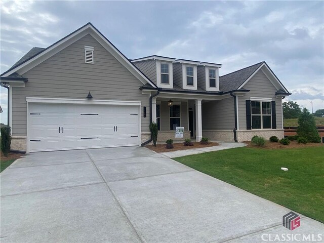 216 Montview Dr, Jefferson, GA 30549 - view of front of home with concrete driveway, a porch, a front yard, an attached garage, and roof with shingles