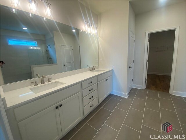 216 Montview Dr, Jefferson, GA 30549 - bathroom featuring walk in shower, double vanity, baseboards, tile patterned flooring, and a spacious closet