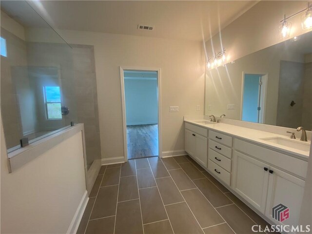 216 Montview Dr, Jefferson, GA 30549 - bathroom with double vanity, tile patterned floors, a walk in shower, and baseboards