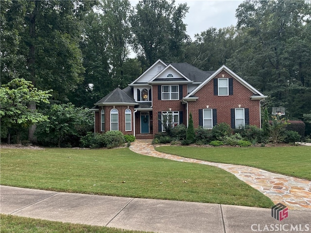 view of front of property featuring brick siding and a front lawn