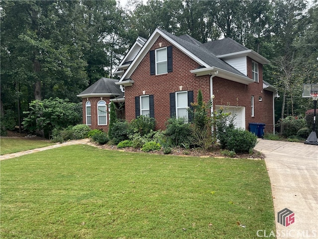 view of front of home with driveway, brick siding, and a front lawn