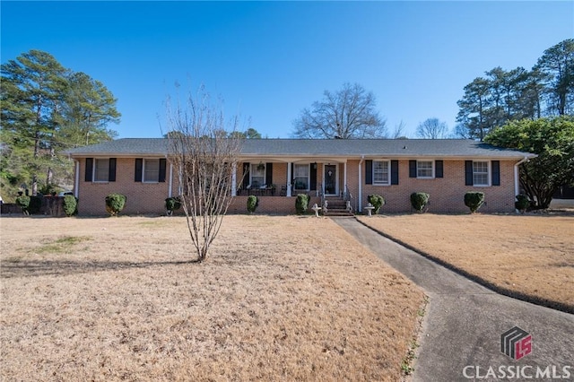 ranch-style home with a front yard and covered porch