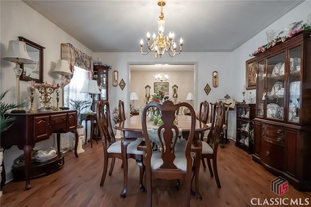 dining room with hardwood / wood-style floors and a chandelier