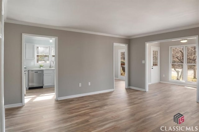 unfurnished living room with sink, light wood-type flooring, and crown molding