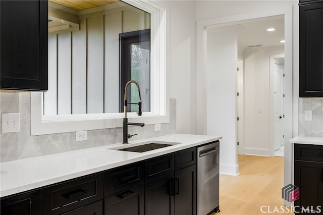 kitchen with light hardwood / wood-style floors, dishwasher, backsplash, and sink