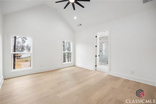 empty room with ceiling fan, high vaulted ceiling, and light hardwood / wood-style floors