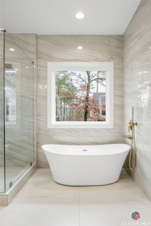 bathroom with tile walls and plus walk in shower