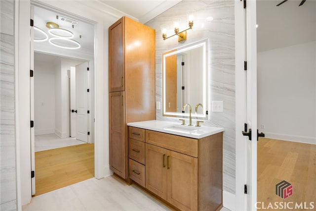 bathroom featuring vanity, hardwood / wood-style floors, and crown molding