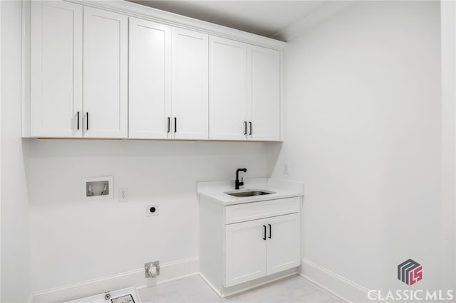 clothes washing area with cabinets, sink, hookup for an electric dryer, and hookup for a washing machine