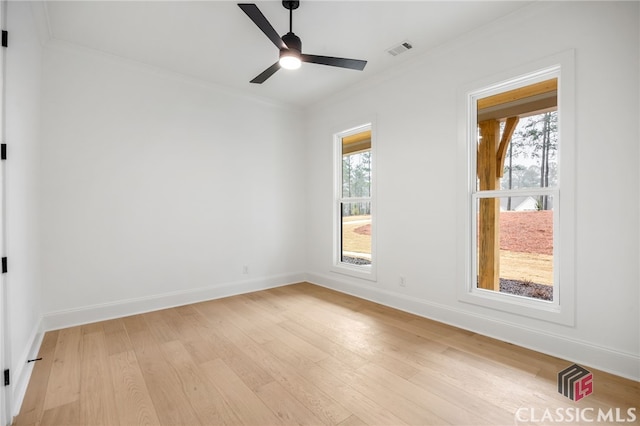 empty room featuring light hardwood / wood-style floors, ceiling fan, a healthy amount of sunlight, and ornamental molding