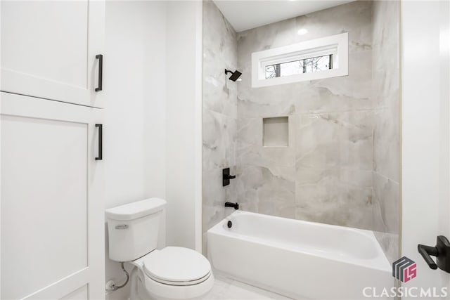 bathroom featuring toilet and tiled shower / bath