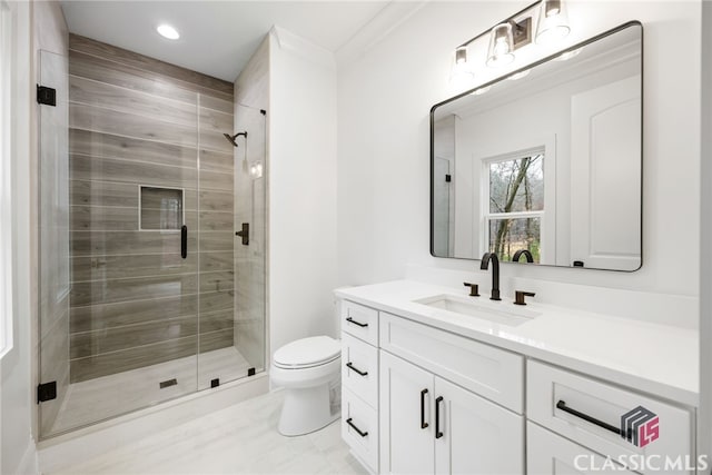 bathroom with toilet, ornamental molding, vanity, and walk in shower