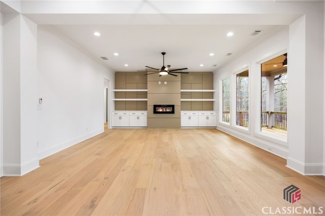 unfurnished living room with a fireplace, ceiling fan, and light hardwood / wood-style flooring