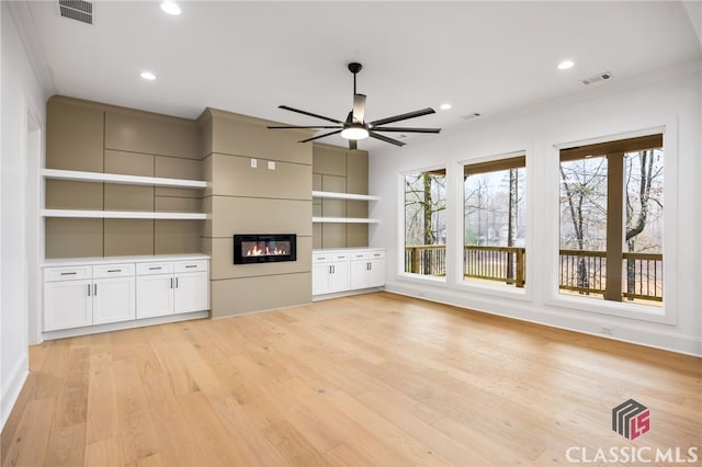 unfurnished living room featuring ceiling fan, crown molding, and light hardwood / wood-style floors