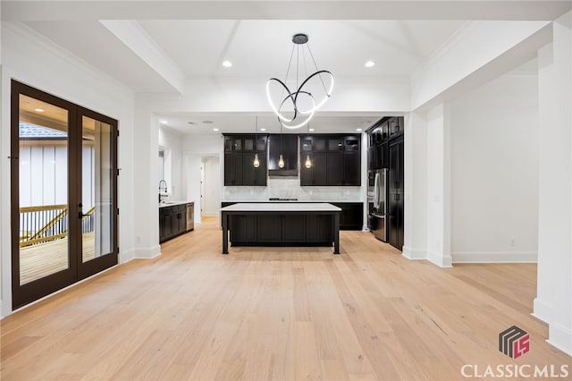 kitchen featuring a chandelier, a center island, decorative light fixtures, french doors, and tasteful backsplash