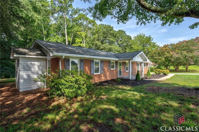 ranch-style home featuring covered porch and a front yard