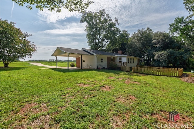 rear view of property with a yard and a carport