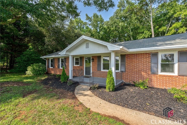 ranch-style house with a front yard and a porch