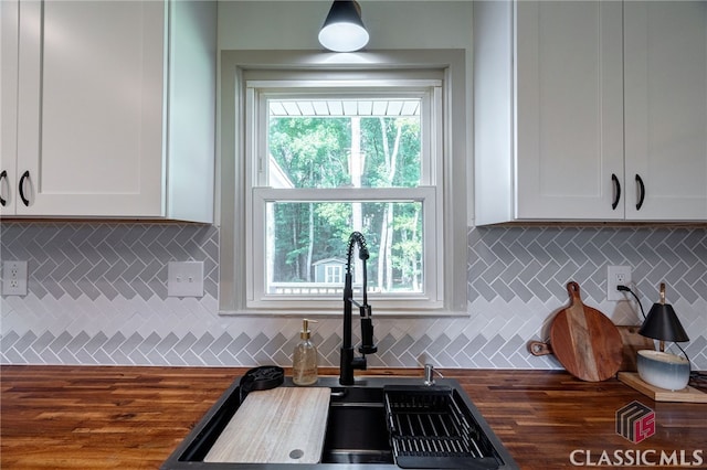 kitchen with white cabinets, sink, butcher block counters, and tasteful backsplash