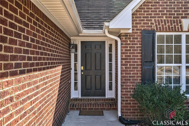 doorway to property with brick siding