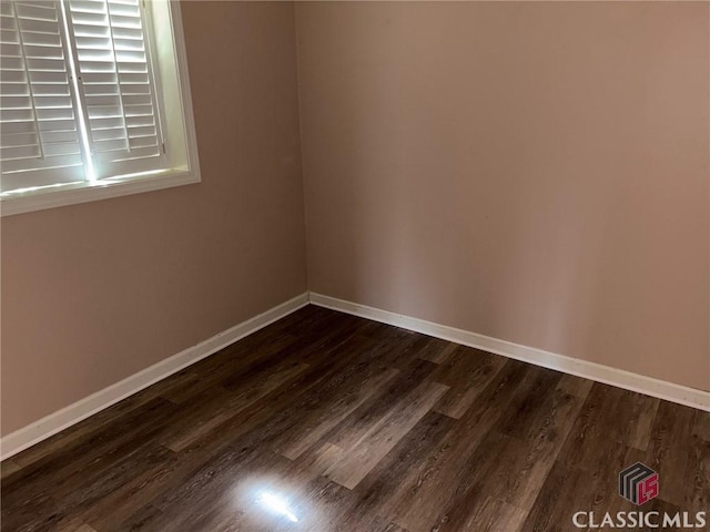 spare room with dark hardwood / wood-style floors