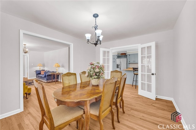 dining room featuring baseboards, a notable chandelier, and wood finished floors