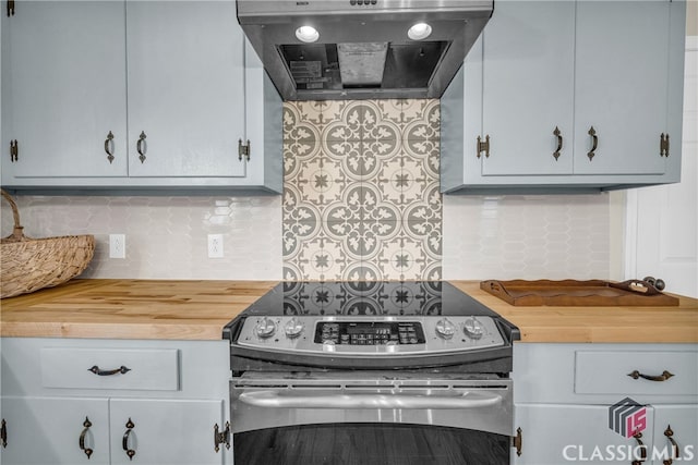 kitchen featuring butcher block countertops, extractor fan, backsplash, and stainless steel range with electric stovetop