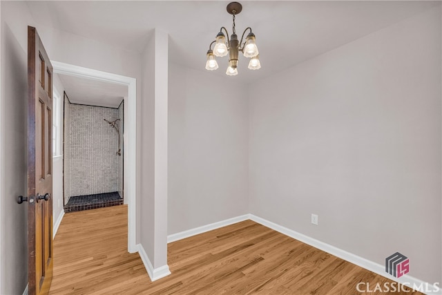 interior space with light wood finished floors, baseboards, and an inviting chandelier