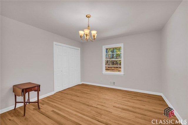 bedroom featuring baseboards, visible vents, a chandelier, and wood finished floors