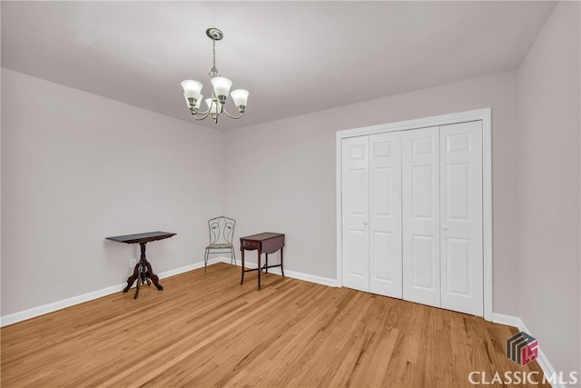 interior space featuring a chandelier, baseboards, and wood finished floors