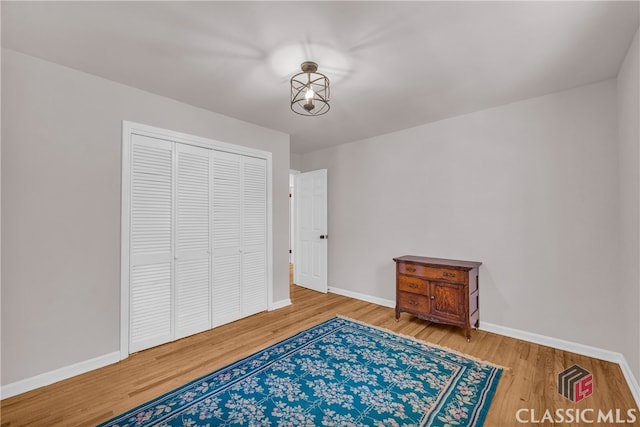 bedroom with a closet, baseboards, and wood finished floors