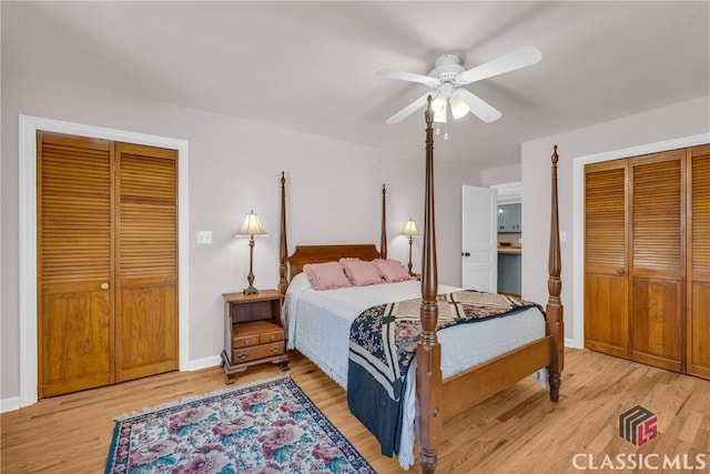 bedroom with ceiling fan, light wood finished floors, multiple closets, and baseboards