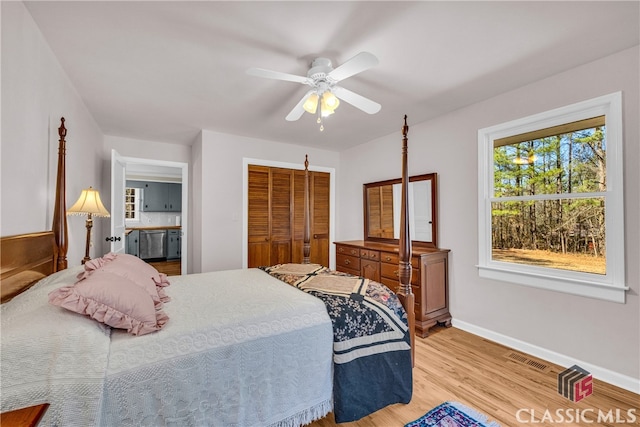 bedroom featuring visible vents, baseboards, a ceiling fan, light wood-style flooring, and a closet