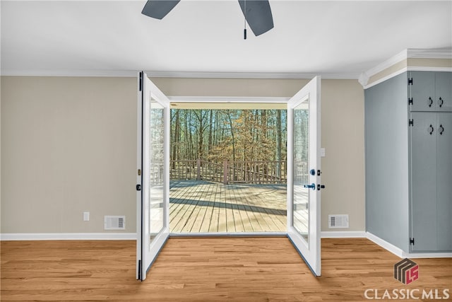 entryway featuring ornamental molding, visible vents, ceiling fan, and light wood-style flooring