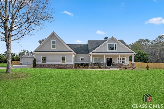 craftsman-style house with board and batten siding, a front yard, stone siding, and a porch