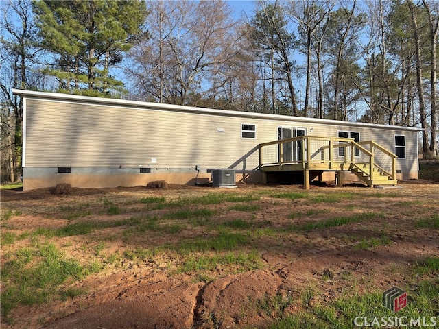 exterior space featuring crawl space, central AC unit, and a wooden deck