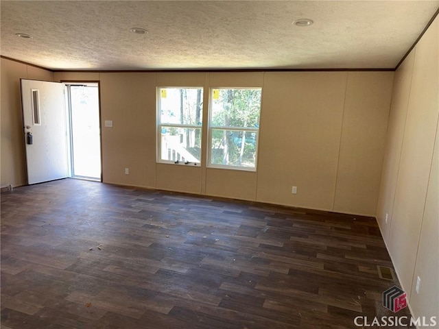 unfurnished room featuring ornamental molding, dark wood-type flooring, and a textured ceiling