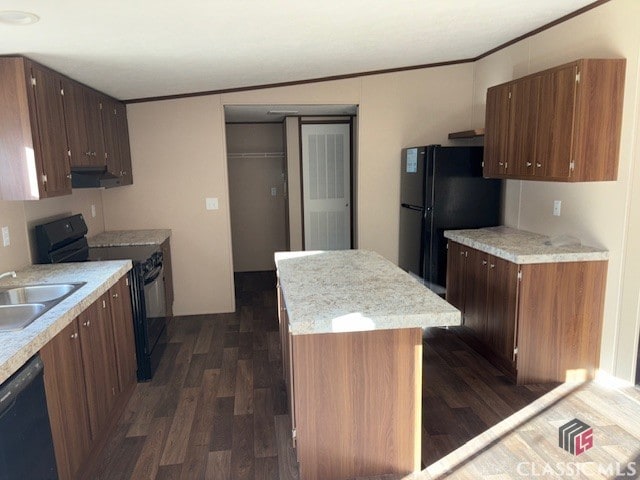 kitchen with a kitchen island, dark wood finished floors, a sink, and black appliances