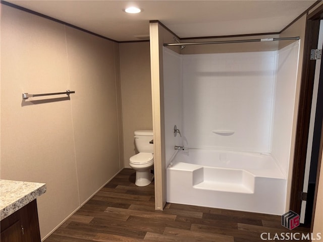 full bath with toilet, washtub / shower combination, wood finished floors, and vanity