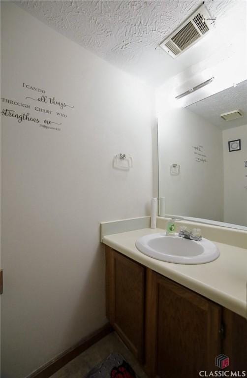 bathroom with a textured ceiling and vanity