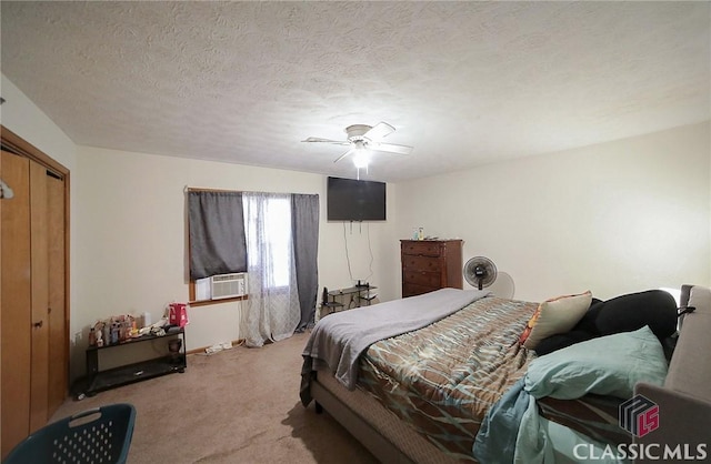 bedroom with ceiling fan, a closet, a textured ceiling, and light colored carpet