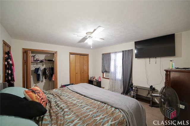 carpeted bedroom featuring ceiling fan and multiple closets