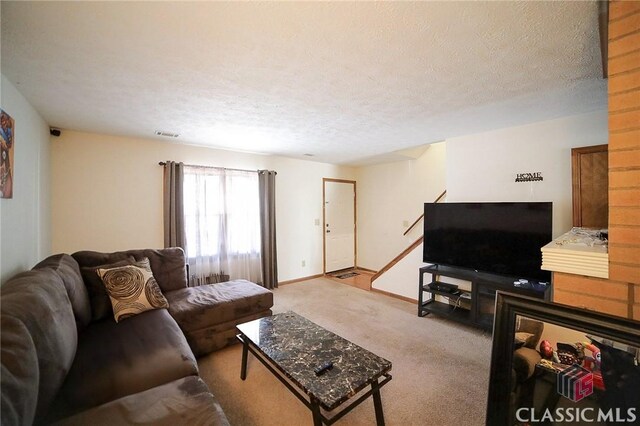 living room featuring a textured ceiling and light carpet